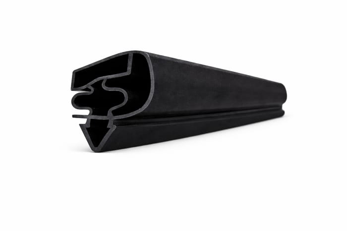 Perfil flexible negro con cámara tubular, dientes de encaje y aleta de sellado